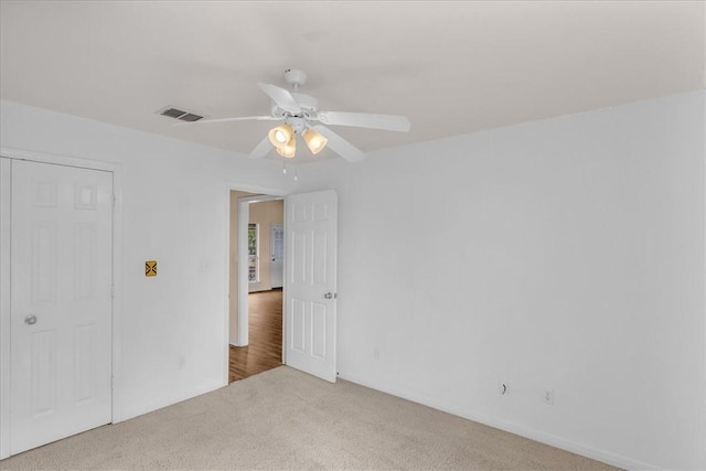 unfurnished bedroom with ceiling fan, a closet, and light colored carpet