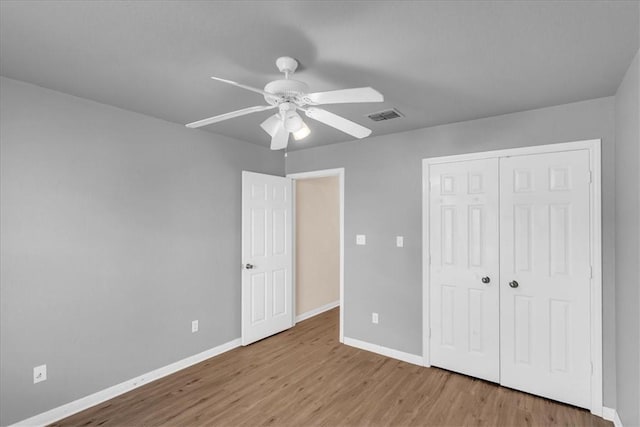 unfurnished bedroom with ceiling fan, light hardwood / wood-style flooring, and a closet