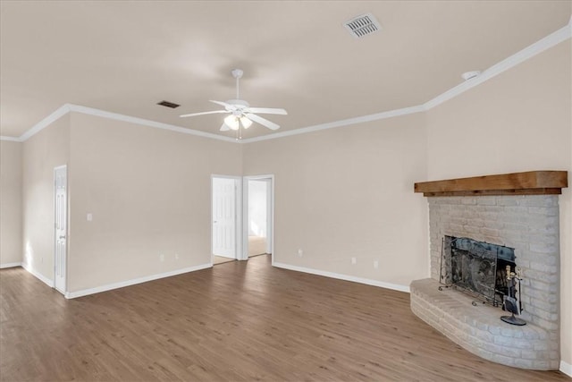 unfurnished living room with a fireplace, hardwood / wood-style flooring, ceiling fan, and ornamental molding