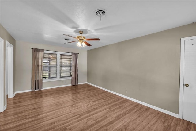 unfurnished room with ceiling fan and hardwood / wood-style flooring