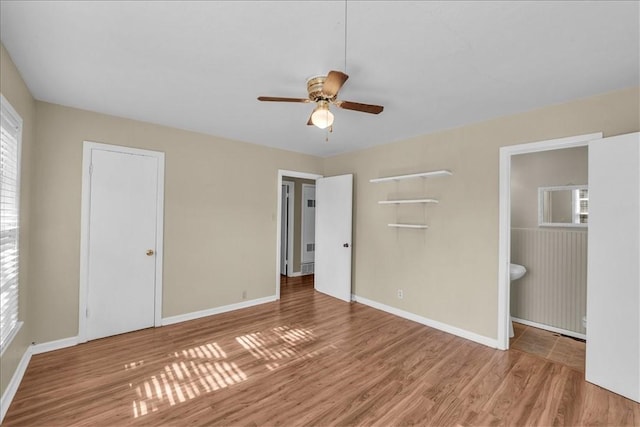 unfurnished bedroom with wood-type flooring, connected bathroom, and ceiling fan