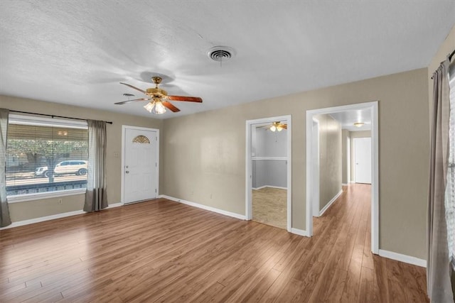 foyer with hardwood / wood-style flooring, ceiling fan, and a textured ceiling