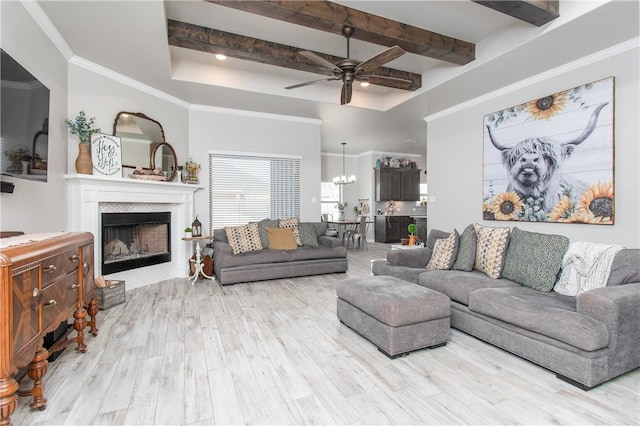 living room featuring ceiling fan with notable chandelier, beamed ceiling, a tray ceiling, crown molding, and light wood-type flooring