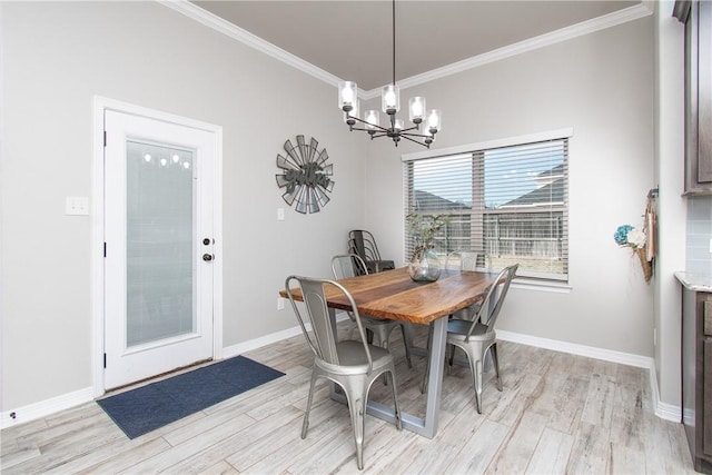 dining space with ornamental molding, an inviting chandelier, and light hardwood / wood-style floors