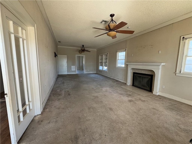 unfurnished living room featuring ceiling fan, ornamental molding, a textured ceiling, and carpet