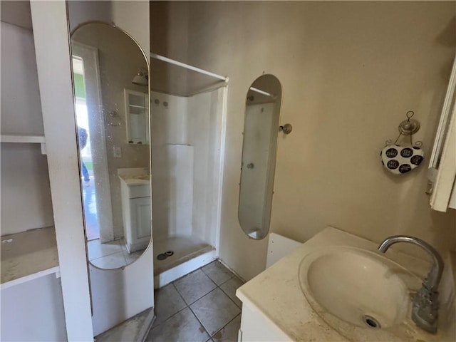 bathroom with a shower, tile patterned floors, and vanity