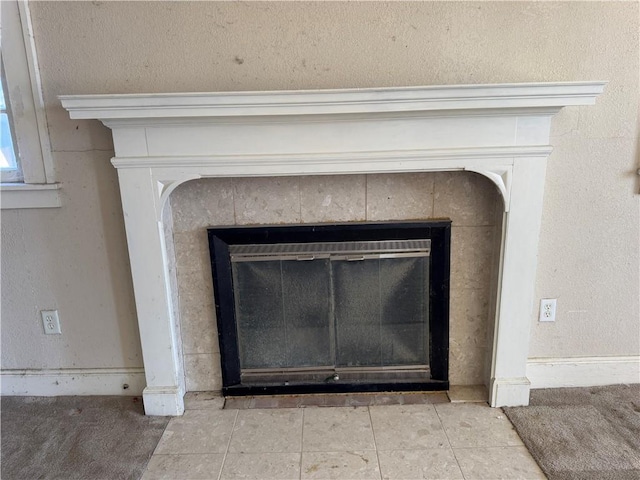 interior details featuring a tiled fireplace