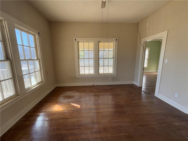 unfurnished dining area featuring ceiling fan, dark hardwood / wood-style floors, and a textured ceiling