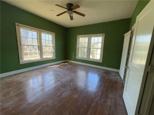 unfurnished room with ceiling fan, dark hardwood / wood-style floors, and a textured ceiling