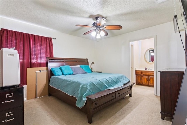 carpeted bedroom featuring a textured ceiling, ensuite bathroom, and ceiling fan