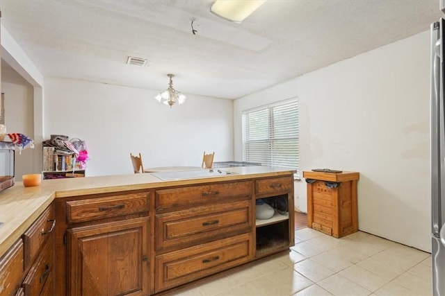 kitchen with a notable chandelier, light tile patterned flooring, and hanging light fixtures