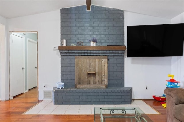 living room with a fireplace, wood-type flooring, and lofted ceiling with beams