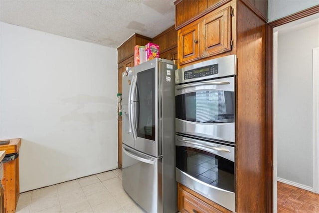 kitchen with a textured ceiling and stainless steel appliances