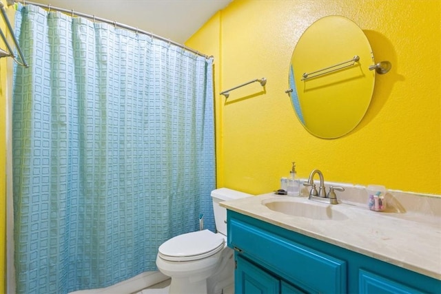 bathroom featuring vanity, curtained shower, and toilet