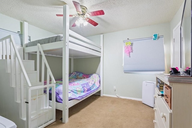 carpeted bedroom featuring a textured ceiling and ceiling fan