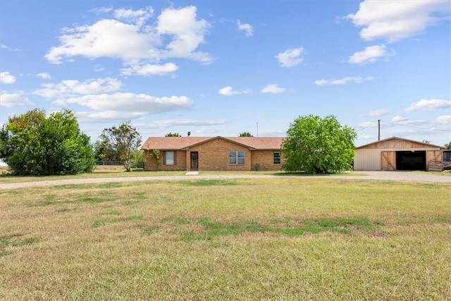 ranch-style home with an outdoor structure and a front lawn