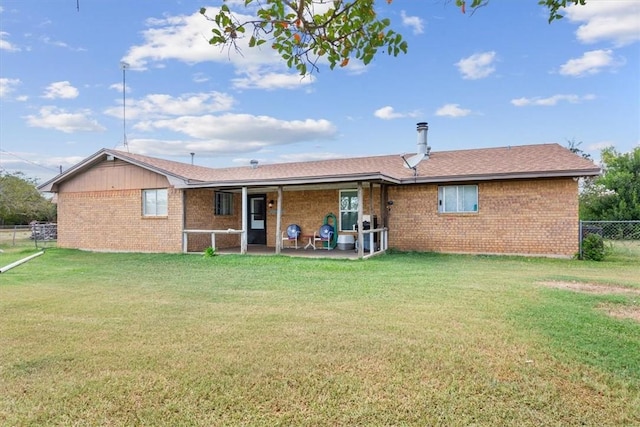 rear view of house featuring a patio area and a yard