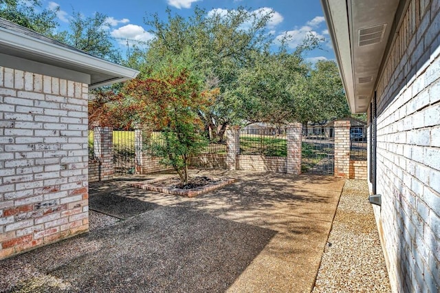 view of yard with visible vents, fence, and a gate