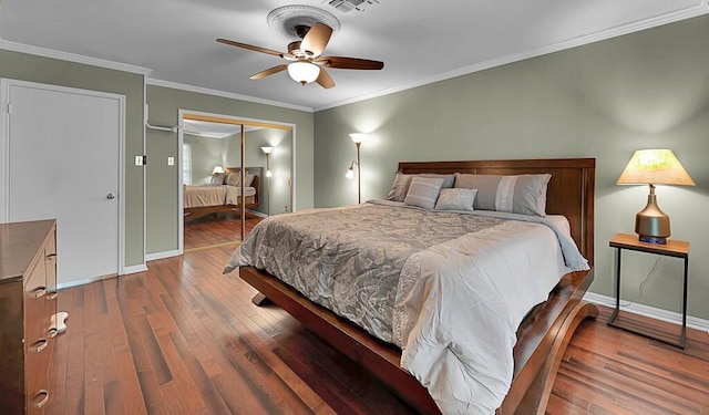 bedroom with a closet, baseboards, hardwood / wood-style floors, and crown molding