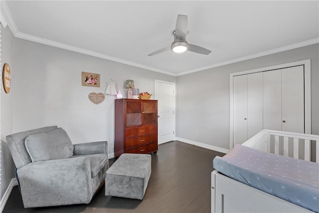 bedroom featuring ornamental molding, dark wood-style flooring, a closet, and baseboards