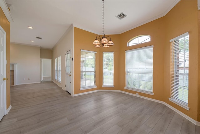 unfurnished dining area with a chandelier, light hardwood / wood-style floors, and crown molding