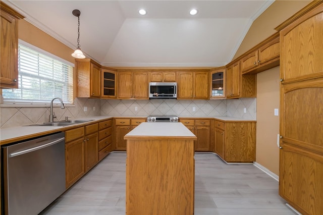 kitchen with sink, a kitchen island, vaulted ceiling, and appliances with stainless steel finishes