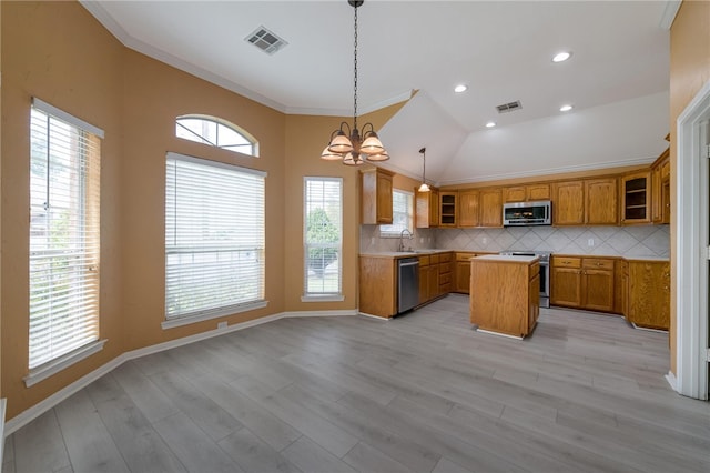 kitchen with stainless steel appliances, a kitchen island, and a healthy amount of sunlight