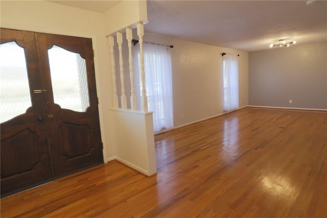 entryway featuring french doors, a textured ceiling, and hardwood / wood-style floors