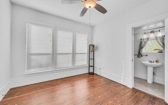 unfurnished bedroom featuring ceiling fan, dark wood-type flooring, and sink