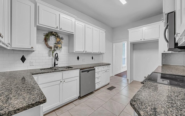 kitchen featuring decorative backsplash, appliances with stainless steel finishes, sink, light tile patterned floors, and white cabinets