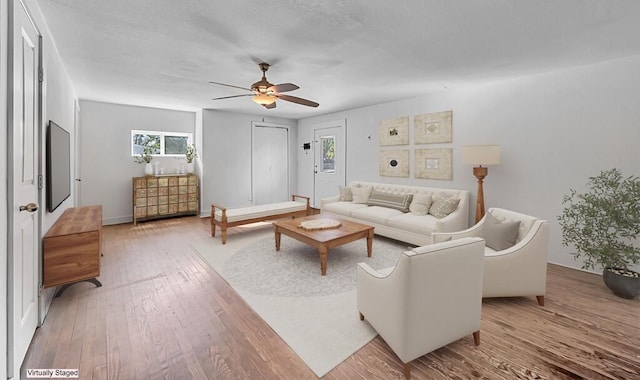 living room featuring hardwood / wood-style flooring, ceiling fan, and a healthy amount of sunlight