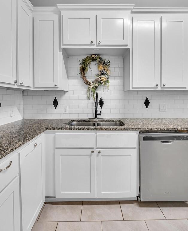 kitchen with dishwasher, decorative backsplash, white cabinets, and dark stone counters