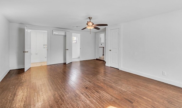 spare room featuring a wall mounted air conditioner, dark hardwood / wood-style flooring, and ceiling fan