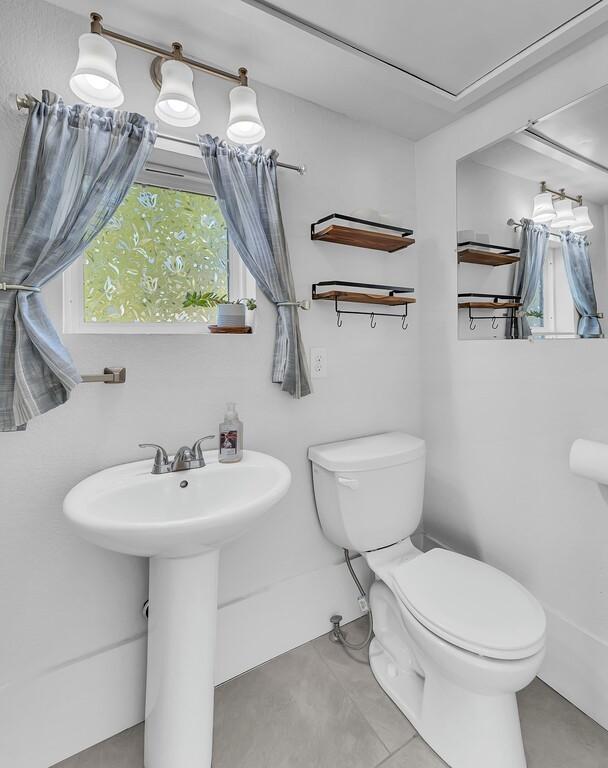 bathroom with tile patterned flooring, toilet, and sink