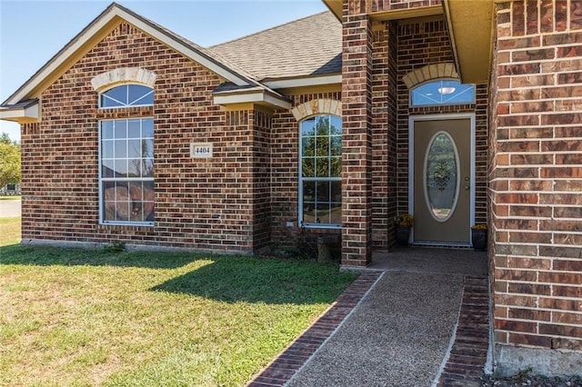 entrance to property with a lawn