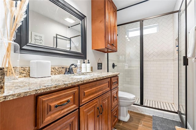 bathroom with vanity, toilet, wood-type flooring, and walk in shower