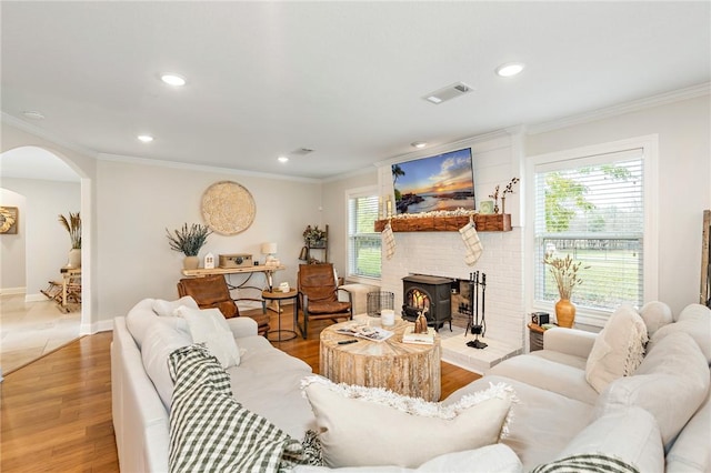 living room with a wealth of natural light, ornamental molding, and hardwood / wood-style flooring