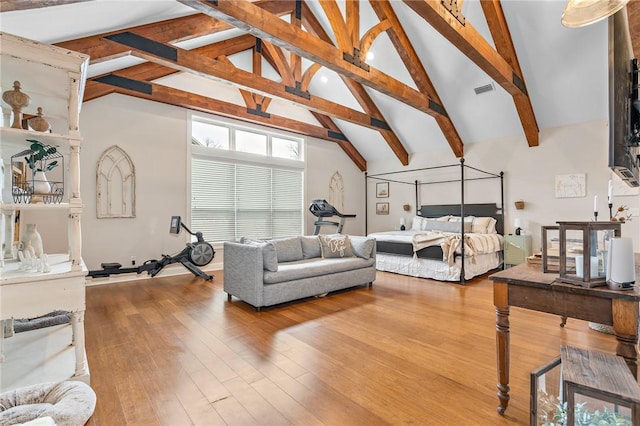 bedroom featuring beamed ceiling, wood-type flooring, and high vaulted ceiling