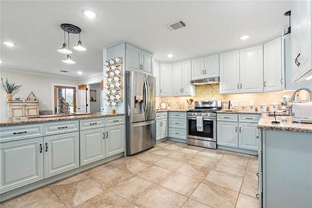 kitchen featuring light stone countertops, sink, stainless steel appliances, tasteful backsplash, and decorative light fixtures