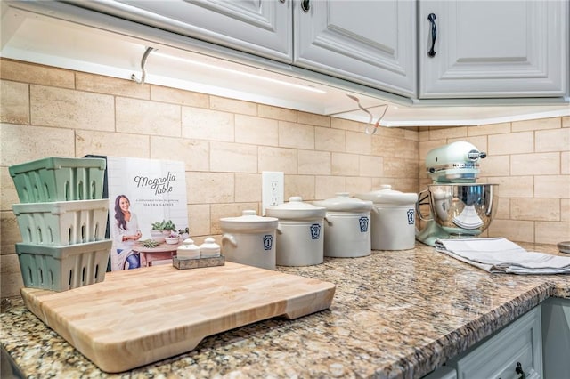 interior space with tasteful backsplash and light stone counters