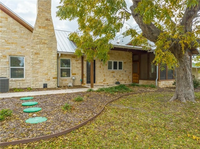 rear view of house featuring a sunroom and cooling unit