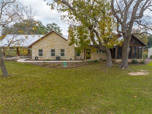 back of house featuring a sunroom, a yard, and central AC