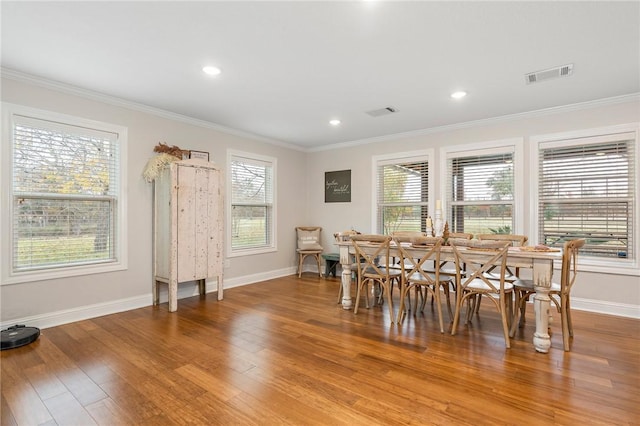 dining area featuring ornamental molding, a healthy amount of sunlight, and hardwood / wood-style flooring