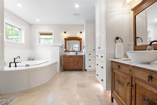 bathroom featuring tile patterned flooring, vanity, and a bath