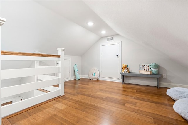 additional living space with lofted ceiling and hardwood / wood-style flooring