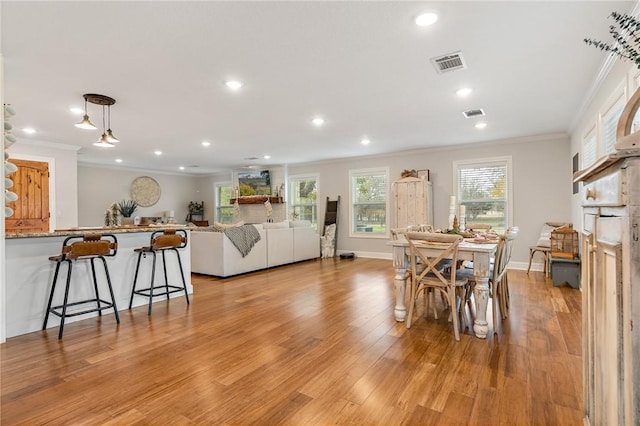 dining room featuring light hardwood / wood-style floors and crown molding