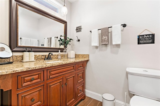 bathroom featuring wood-type flooring, vanity, and toilet