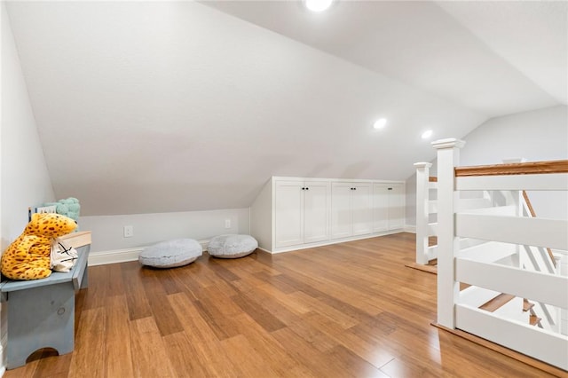 additional living space with lofted ceiling and light hardwood / wood-style flooring