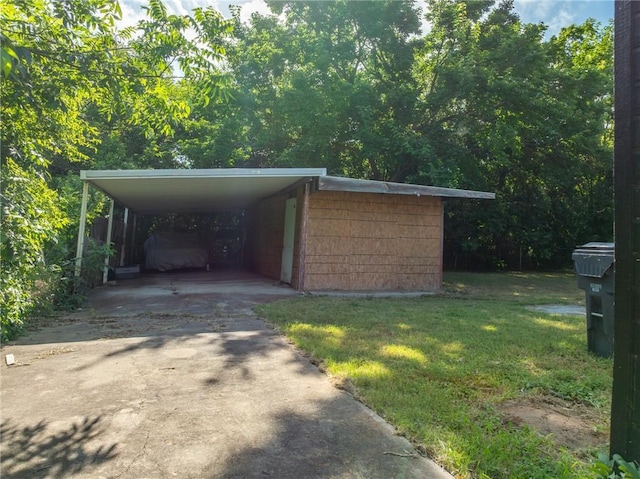 view of outbuilding with a lawn and a carport