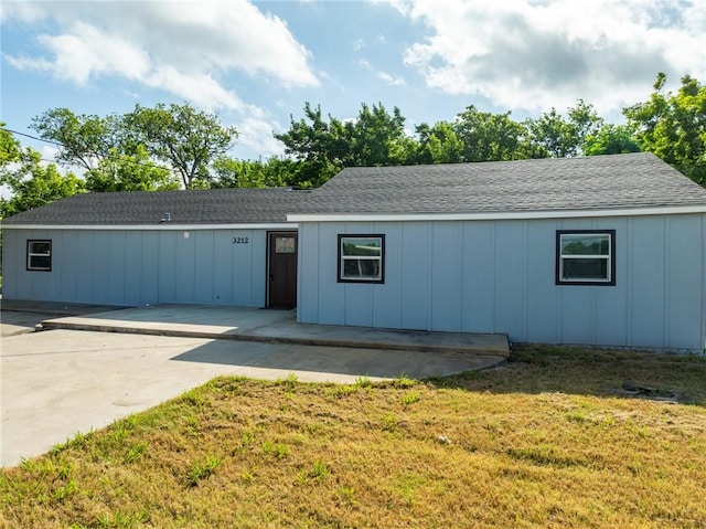 ranch-style home with a front lawn and a patio area